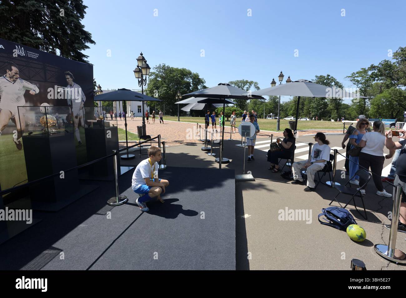 Junger Fußballspieler posiert für ein Foto vor den Goldenen Bälle im Taras Shevchenko Central Park of Culture and Leisure. Der Zweck der Veranstaltung ist die Beschaffung von Geldmitteln durch den Kauf von Souvenirs für das Kinderturnier „Schulball“ des ukrainischen Fußballverbandes. Der Ballon d’Or („Goldener Ball“) ist ein jährlicher Fußballpreis, der seit 1956 von der französischen Zeitschrift France Football verliehen wird, um den Spieler zu ehren, der in der vergangenen Saison die besten Leistungen gezeigt hat. Drei ukrainische Spieler haben diese Auszeichnung erhalten: OLEH Blokhin 1975, Ihor Bielanov 1986 und Andrii Schewtschenko 2004. Stockfoto