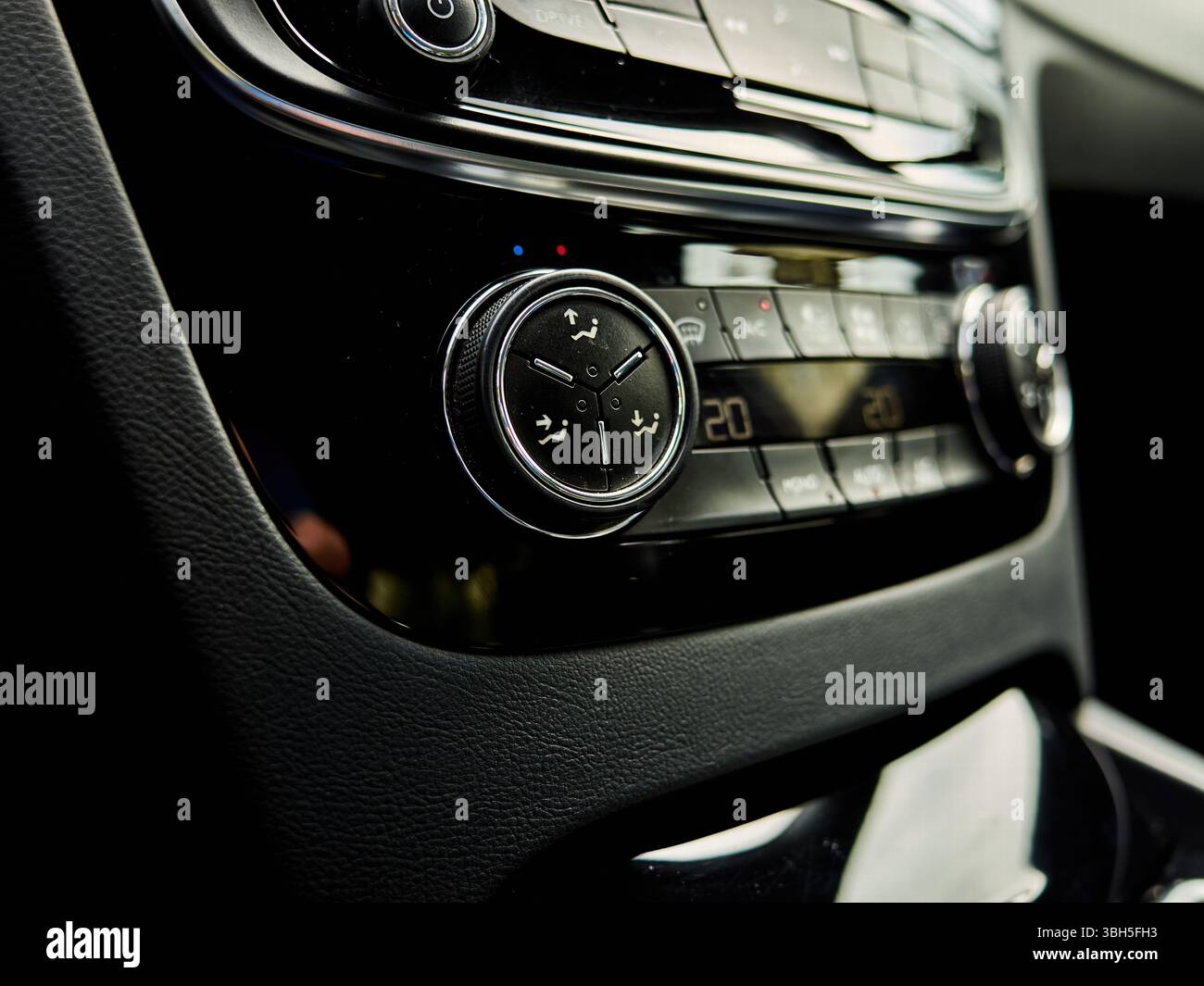 Die Klimaanlage des Fahrzeugs wird mit einer Temperatur von 20 Grad angezeigt. Die Bedienelemente sind schwarz und die Tasten rot Stockfoto