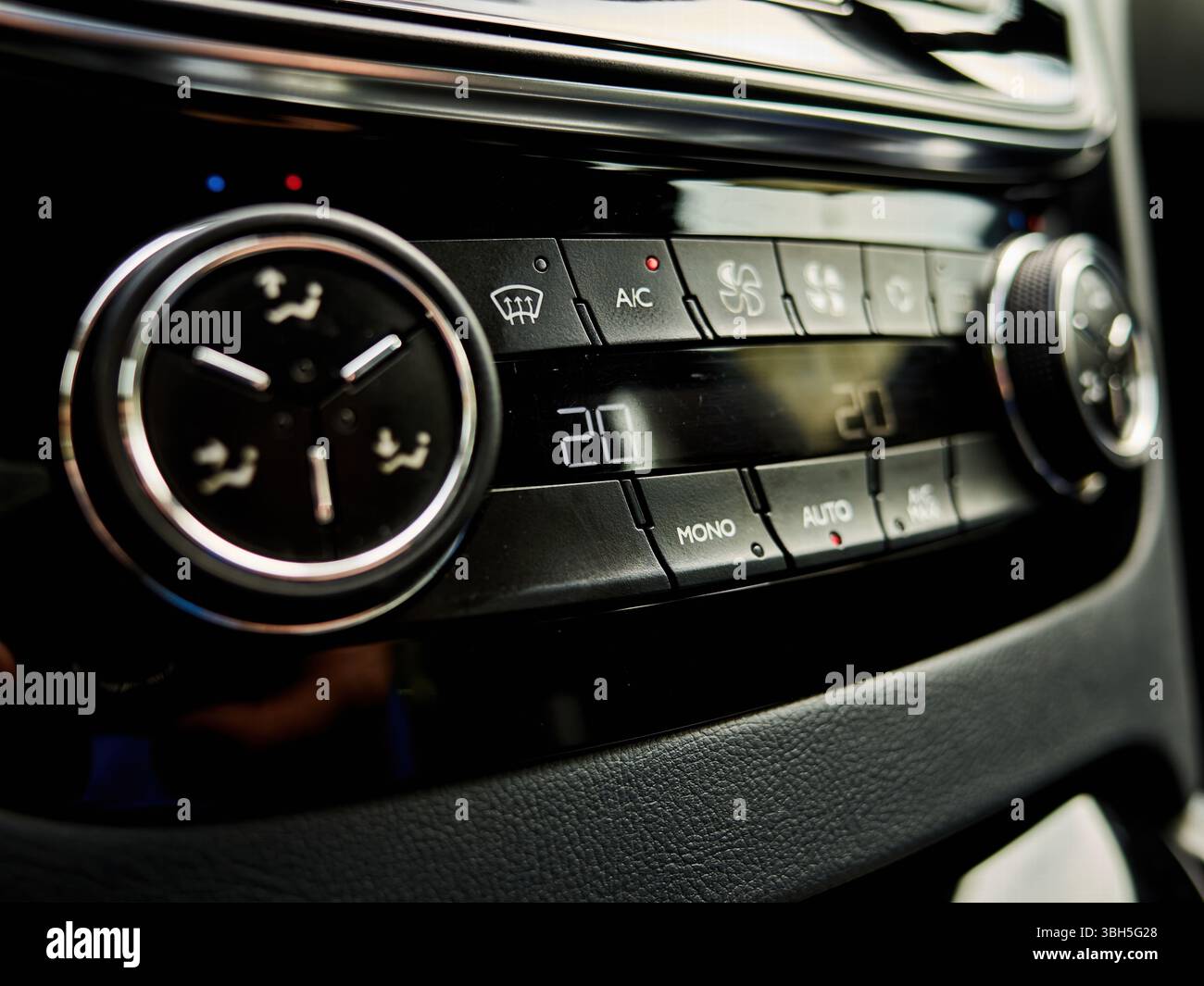 Die Klimaanlage des Fahrzeugs wird mit einer Temperatur von 20 Grad angezeigt. Die Bedienelemente sind schwarz und die Tasten rot Stockfoto