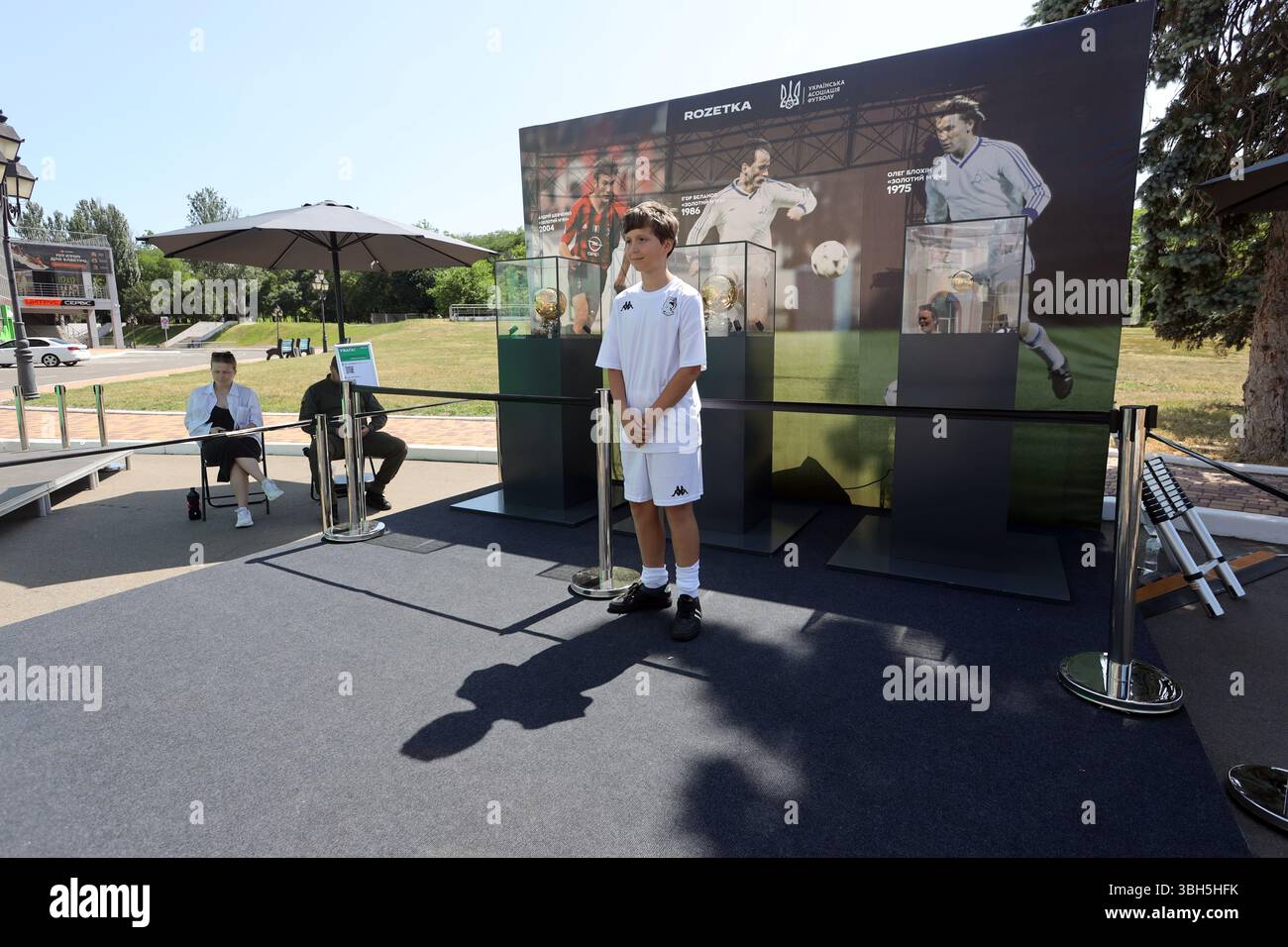 7. Juni 2025, Odessa, Ukraine: Junger Fußballspieler posiert für ein Foto vor den Goldenen Bälle im zentralen Kultur- und Freizeitpark Taras Schewtschenko. Der Zweck der Veranstaltung ist die Beschaffung von Andenken für das Kinderturnier ''Schulball'' vom ukrainischen Fußballverband. Der Ballon d'Or ('Goldener Ball') ist ein jährlicher Fußballpreis, der seit 1956 von der französischen Zeitschrift France Football verliehen wird, um den Spieler zu ehren, der in der vergangenen Saison die besten Leistungen gezeigt hat. Drei ukrainische Spieler haben diese Auszeichnung erhalten: OLEH Blokhin 1975, Ihor Bielanov 1986, A Stockfoto