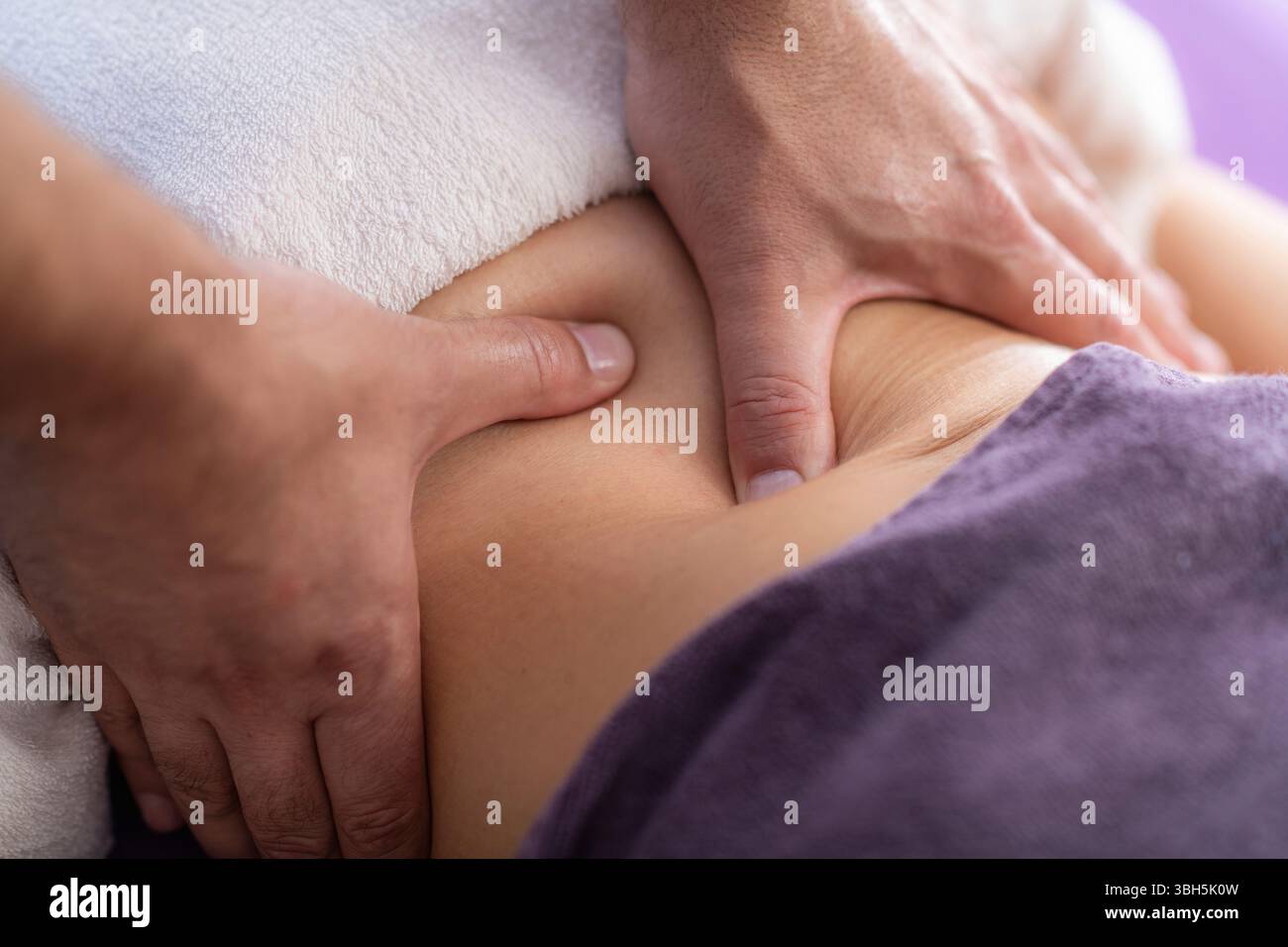 Der Physiotherapeut bietet eine Sportmassage auf dem Rücken des Athleten an, um Muskelschmerzen zu lindern, die Flexibilität zu verbessern und eine schnellere Erholung nach intensiven Workouts oder Rückenverletzungen zu fördern. Stockfoto