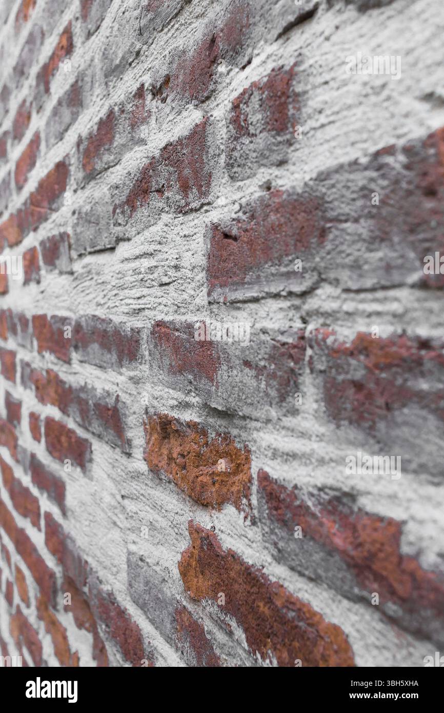 Alte rote Ziegelmauer mit weißem Beton. Selektiver Fokus auf die Details Stockfoto