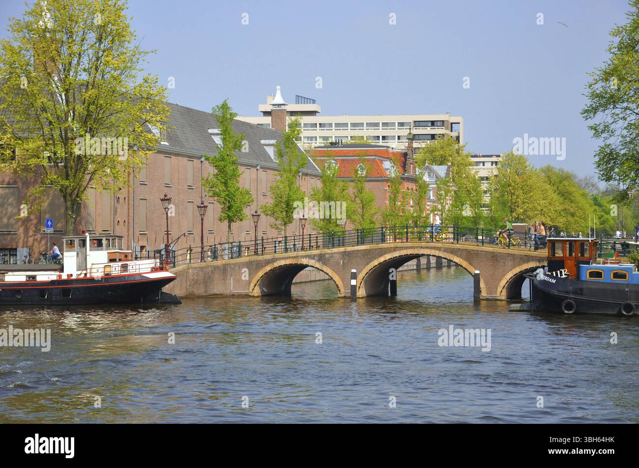 Schöner Fluss mit Schiffen, Eremitage und Amstel Brücke in Amsterdam, Holland (Niederlande) Stockfoto