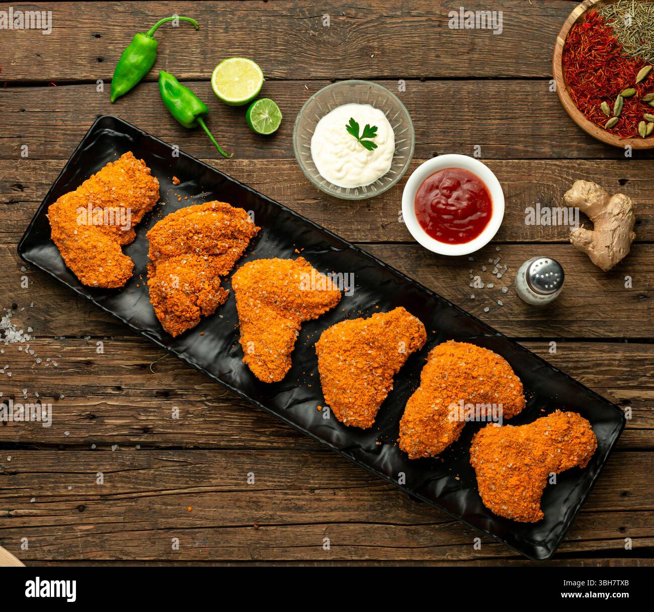 Rohe knusprige Hähnchenflügel mit Soße, Blick von oben. Stockfoto