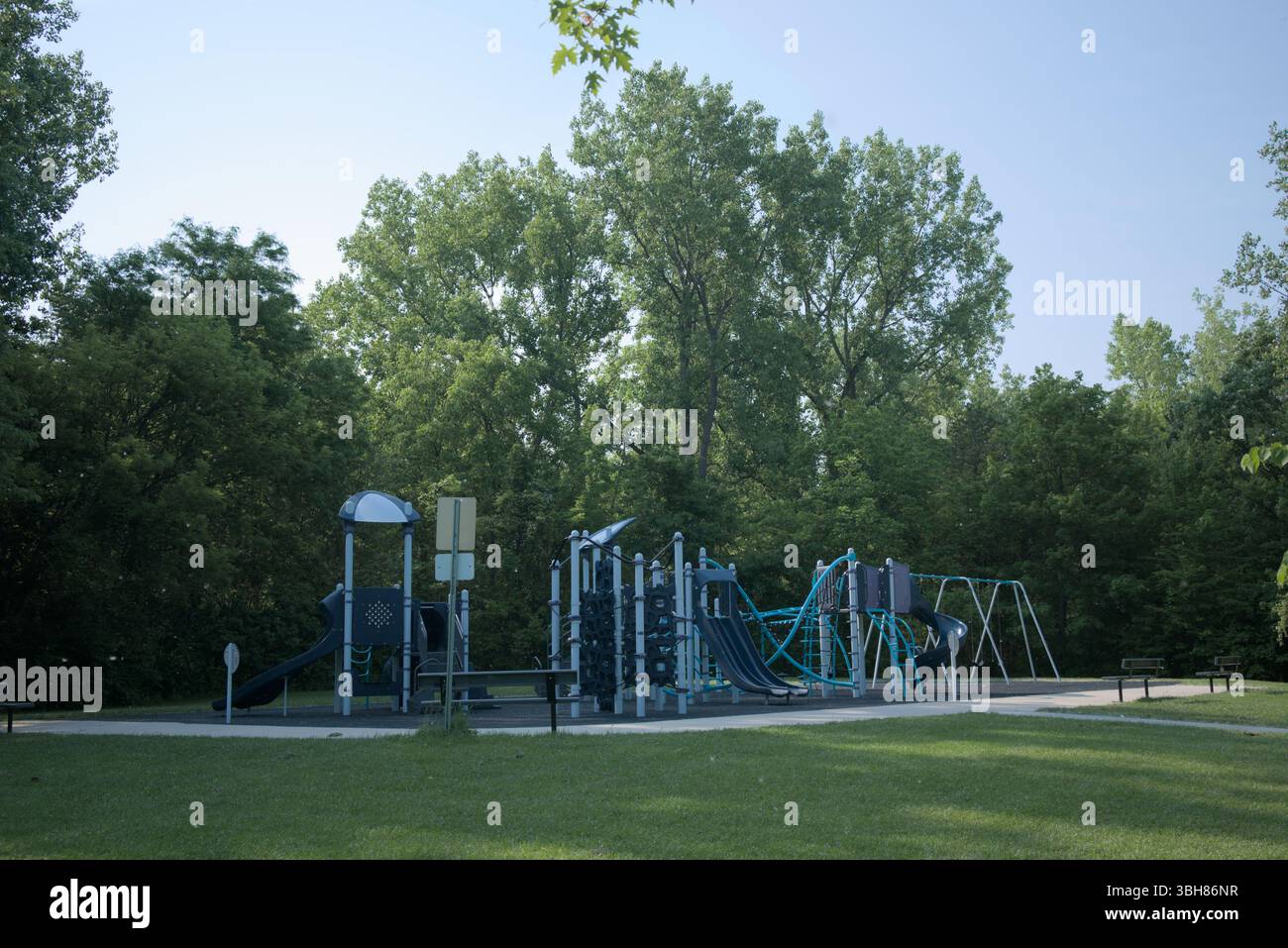 Moderner Outdoor-Spielplatz inmitten grüner Bäume an einem sonnigen Tag Stockfoto