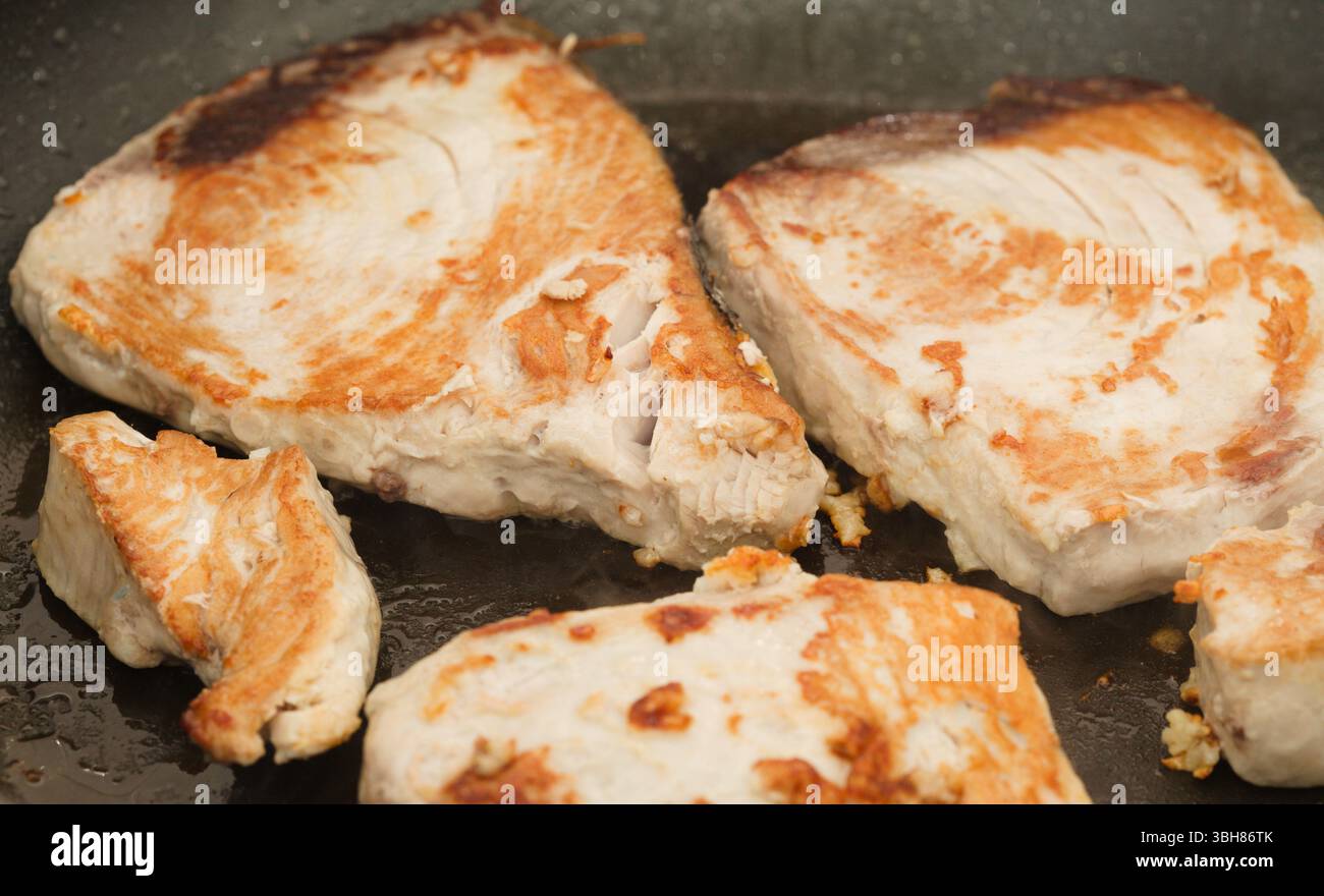 Gelbflossenthunfischsteaks, die in einer Pfanne gebraten werden Stockfoto