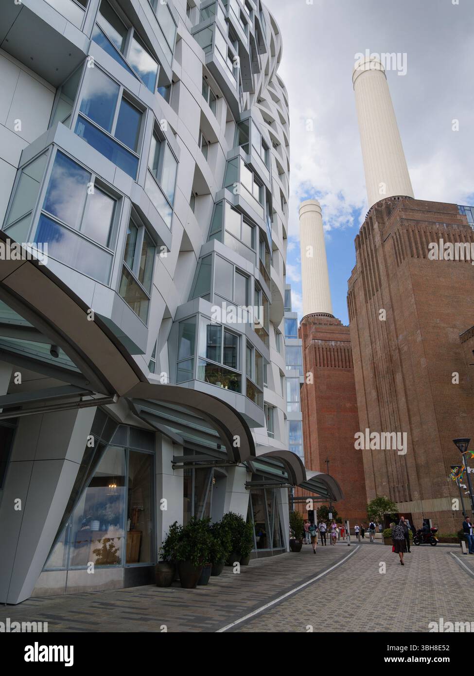 Unorthodoxe Wohnhäuser am Prospect Place, entworfen von Frank Gehry, stehen in kühlem Kontrast zum legendären Battersea Power Station in Nine Elms London, Großbritannien Stockfoto