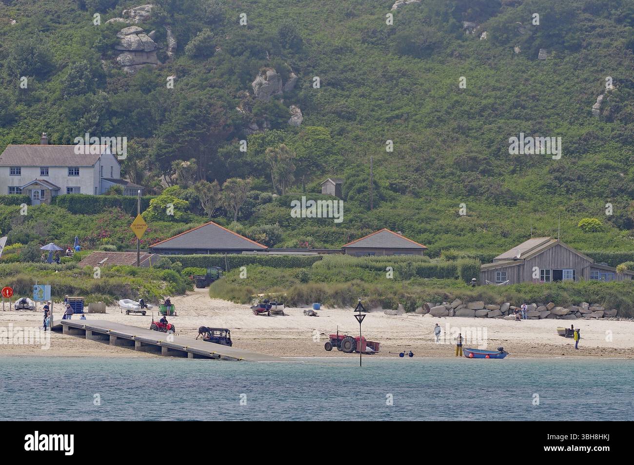 Küstenlandschaft mit Strand, Häusern und grünen Hügeln im Hintergrund, entspannte Atmosphäre, Isles of Scilly, Cornwall, England, Großbritannien Stockfoto