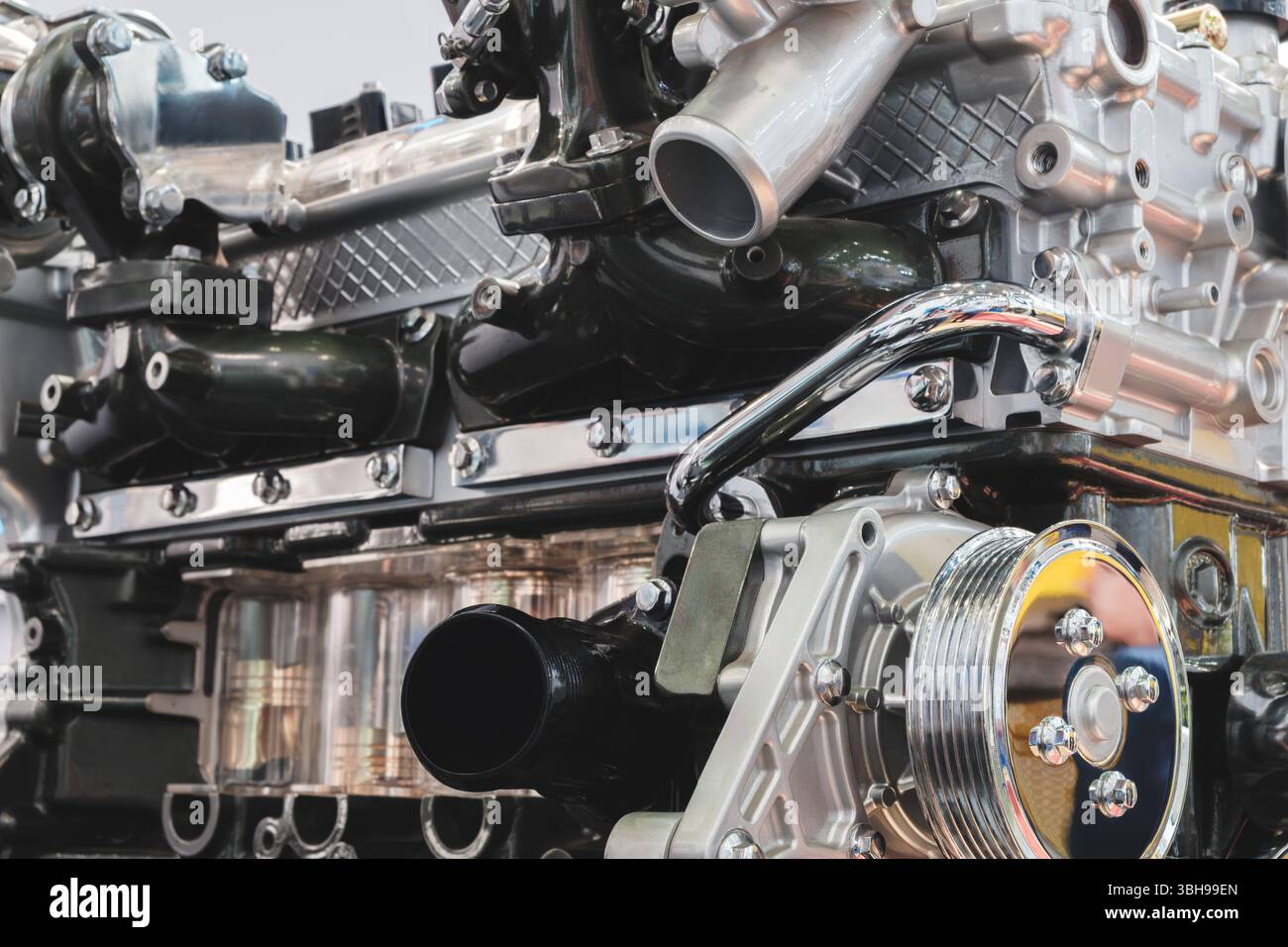 Nahaufnahme eines Automotors mit vielen Details. Der Motor ist ein komplexes Maschinenteil mit vielen Teilen und Komponenten. Das Konzept von Ehrfurcht und Bewunderung Stockfoto