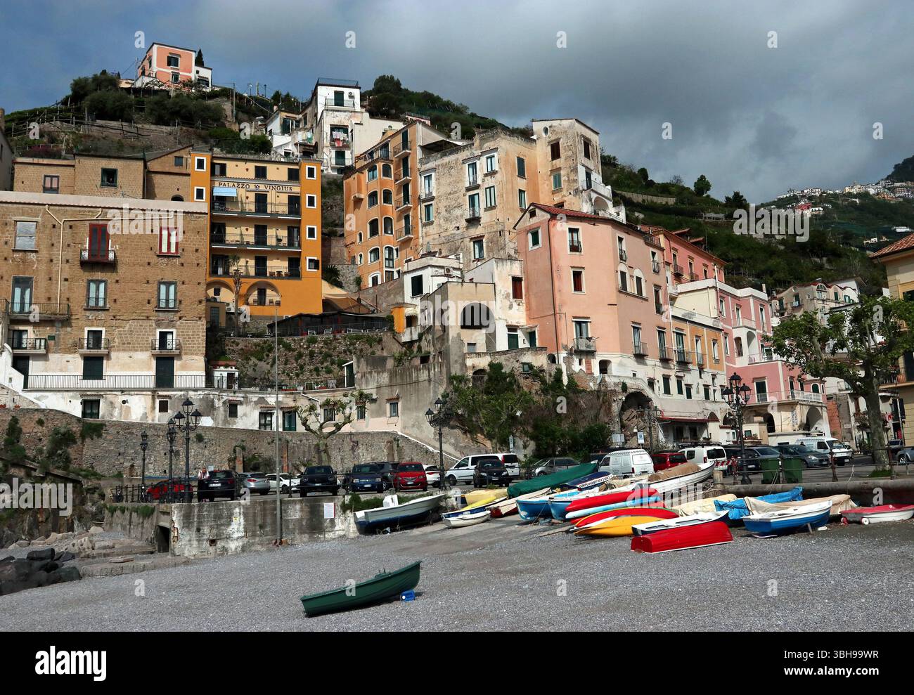 In Minori, einer kleinen Stadt an der Amalfiküste, erheben sich pastellfarbene Häuser über dem Strand und kurvenförmig um die Küste herum Stockfoto