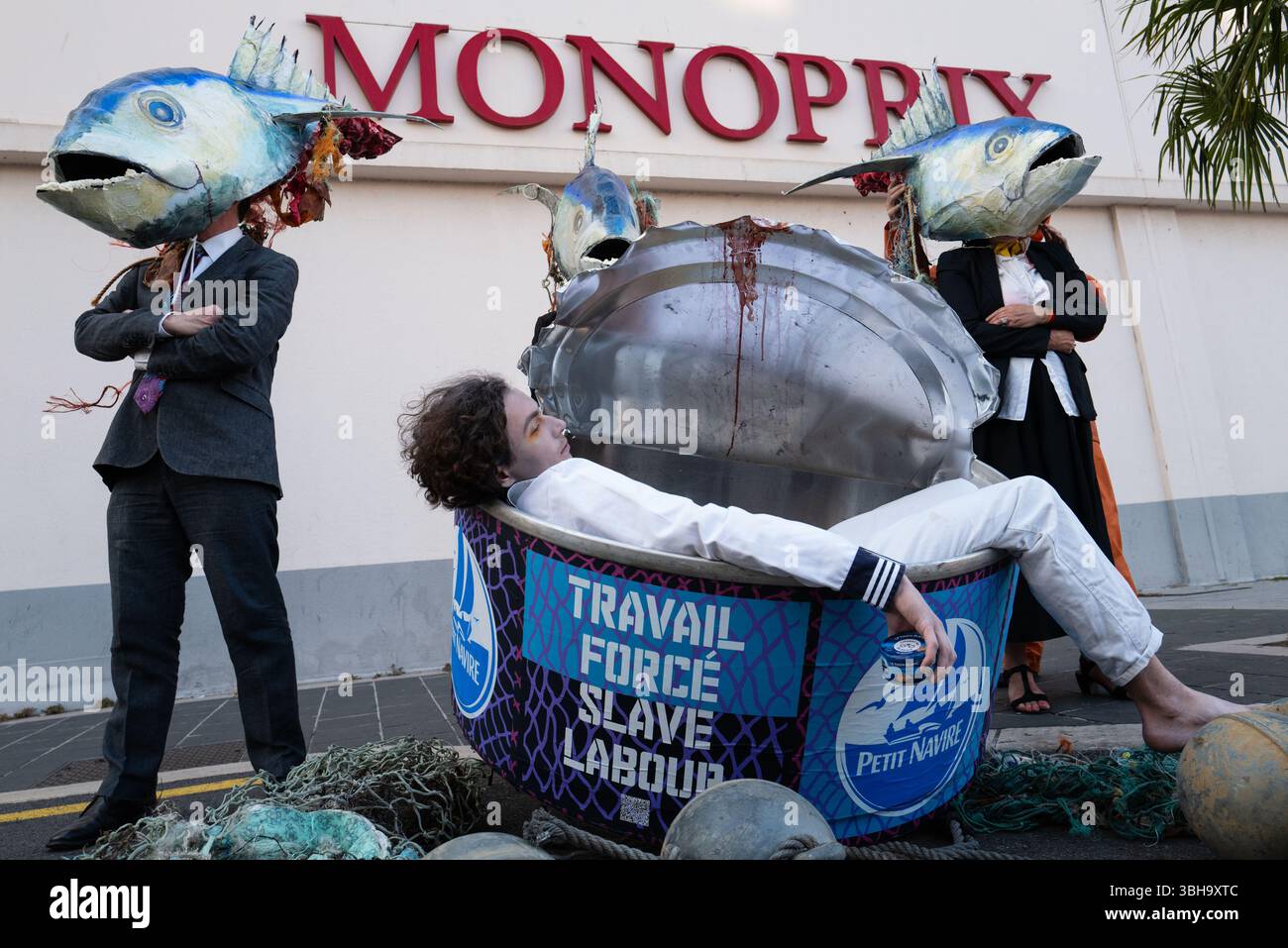 Nizza, England, Frankreich. Juni 2025. Am Welttag der Ozeane veranstalteten Aktivisten der Ocean Rebellion einen theatralischen Protest vor einem Monoprix-Supermarkt in Nizza, Frankreich, um die Bedenken hinsichtlich der industriellen Thunfischfangpraxis zu beleuchten. Die Demonstration zeigte Künstler, die eine riesige Dose Petit Navire Thunfisch mit einem˜toten Seemann enthüllten, begleitet von einer satirischen Darbietung des französischen Liedes˜Il Ã Tait un Petit Navire. Mit dem Protest sollte auf angebliche Menschenrechtsverletzungen und Umweltauswirkungen im Zusammenhang mit der Thunfischfischerei, insbesondere im Zusammenhang mit der Marine Stewardship, hingewiesen werden Stockfoto