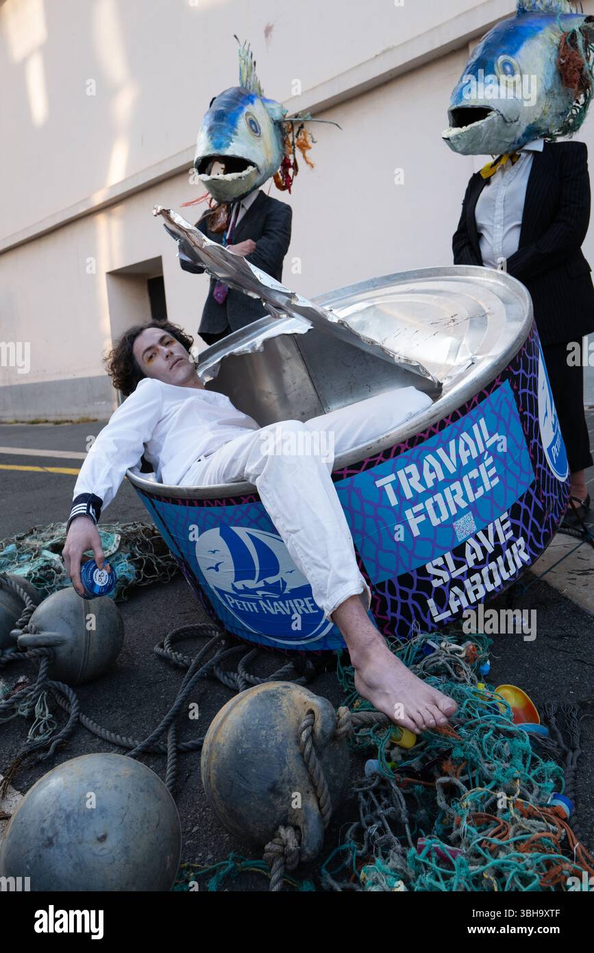 Nizza, England, Frankreich. Juni 2025. Am Welttag der Ozeane veranstalteten Aktivisten der Ocean Rebellion einen theatralischen Protest vor einem Monoprix-Supermarkt in Nizza, Frankreich, um die Bedenken hinsichtlich der industriellen Thunfischfangpraxis zu beleuchten. Die Demonstration zeigte Künstler, die eine riesige Dose Petit Navire Thunfisch mit einem˜toten Seemann enthüllten, begleitet von einer satirischen Darbietung des französischen Liedes˜Il Ã Tait un Petit Navire. Mit dem Protest sollte auf angebliche Menschenrechtsverletzungen und Umweltauswirkungen im Zusammenhang mit der Thunfischfischerei, insbesondere im Zusammenhang mit der Marine Stewardship, hingewiesen werden Stockfoto