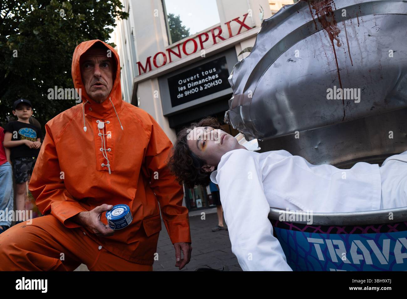 Nizza, England, Frankreich. Juni 2025. Am Welttag der Ozeane veranstalteten Aktivisten der Ocean Rebellion einen theatralischen Protest vor einem Monoprix-Supermarkt in Nizza, Frankreich, um die Bedenken hinsichtlich der industriellen Thunfischfangpraxis zu beleuchten. Die Demonstration zeigte Künstler, die eine riesige Dose Petit Navire Thunfisch mit einem˜toten Seemann enthüllten, begleitet von einer satirischen Darbietung des französischen Liedes˜Il Ã Tait un Petit Navire. Mit dem Protest sollte auf angebliche Menschenrechtsverletzungen und Umweltauswirkungen im Zusammenhang mit der Thunfischfischerei, insbesondere im Zusammenhang mit der Marine Stewardship, hingewiesen werden Stockfoto