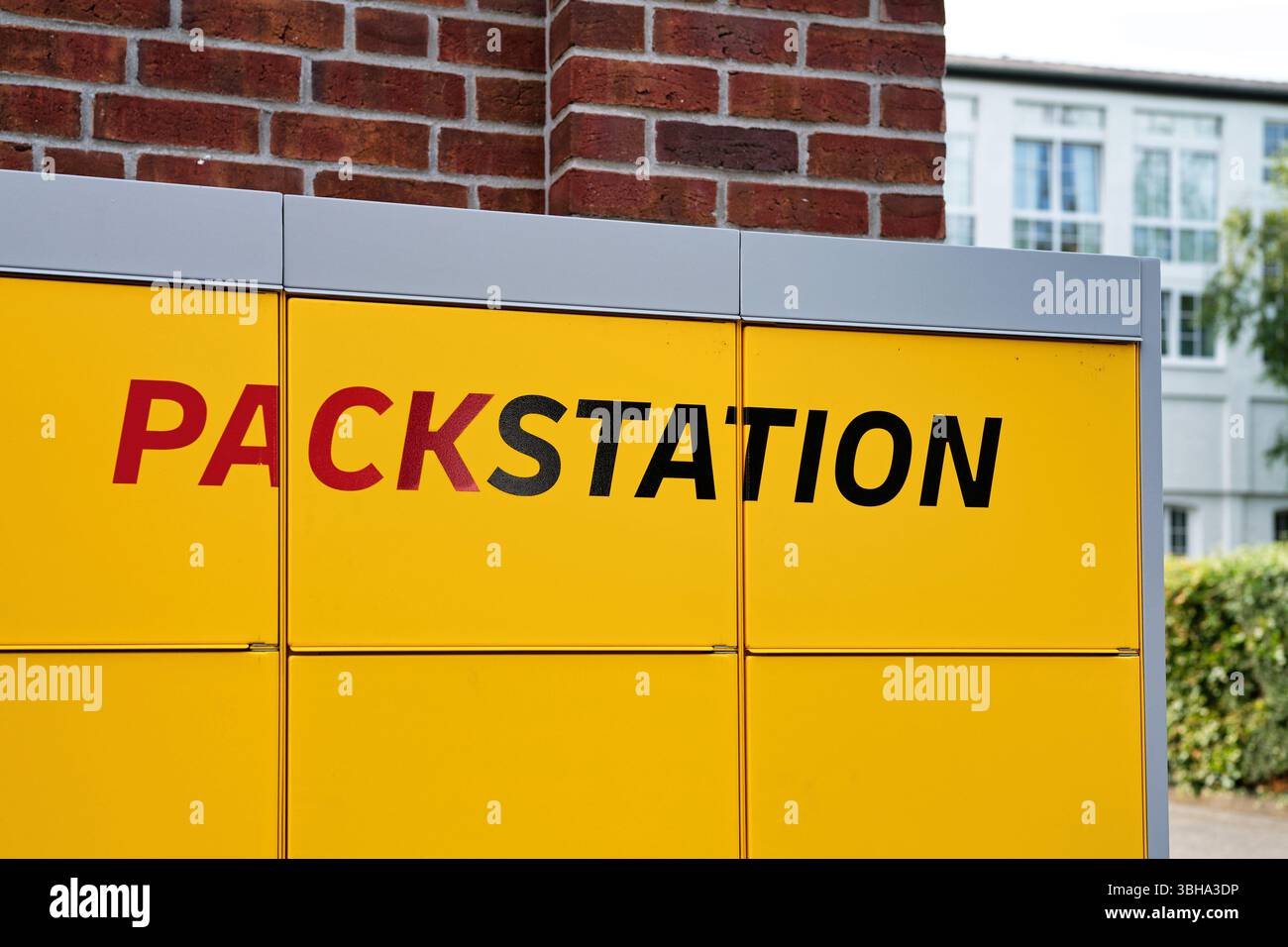 Köln, Deutschland 08. Juni 2025: DHL Packstation mit einem prominenten „PACKSTATION“-Logo in einem städtischen oder vorstädtischen Umfeld Stockfoto