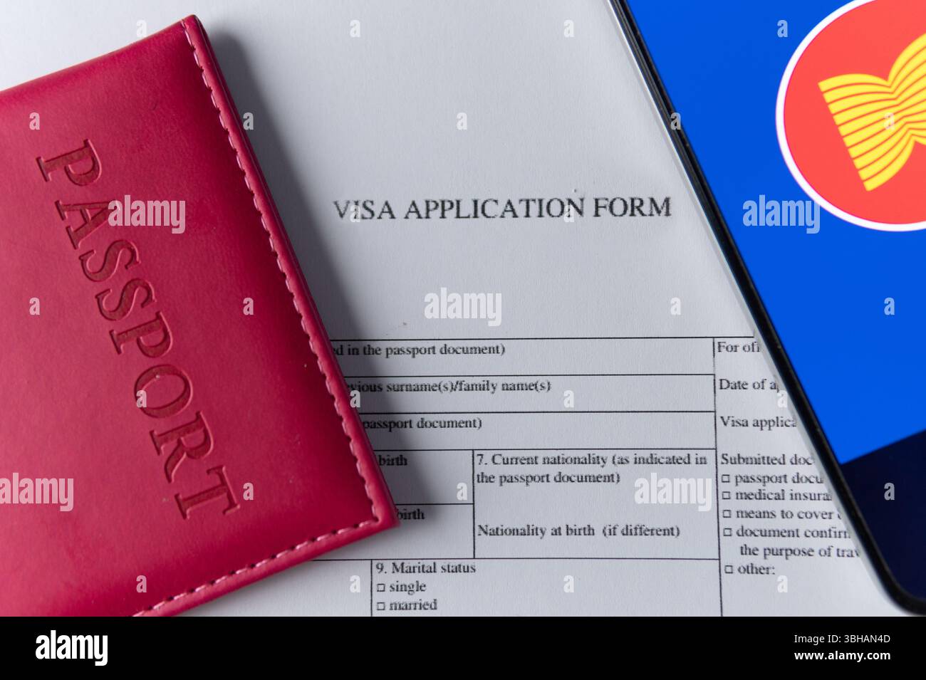 Einen Reisepass, ein Visumantragsformular und ein Smartphone mit der ASEAN-Flagge auf einem Holztisch. Internationales Reisekonzept und globales Verbindungskonzept Stockfoto