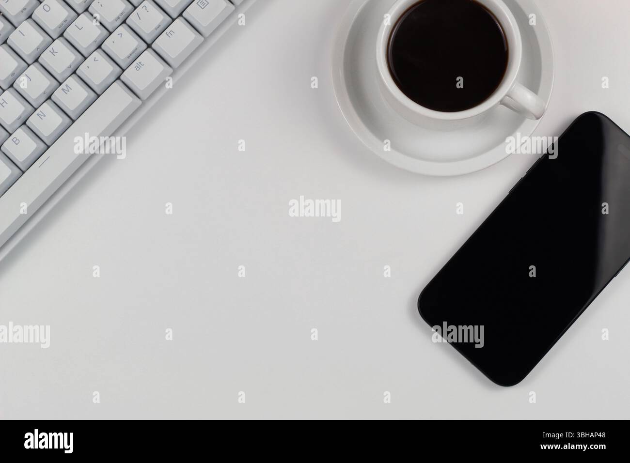 Schreibtisch flach mit weißer Tastatur und Smartphone Stockfoto