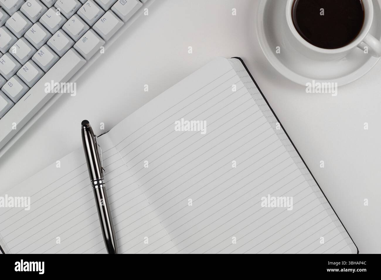 Schreibtisch flach mit weißer Tastatur und Notizblock Stockfoto