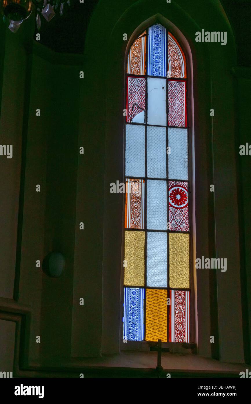 Licht durch Glauben – bunter Glasbogen in der Kirche Stockfoto