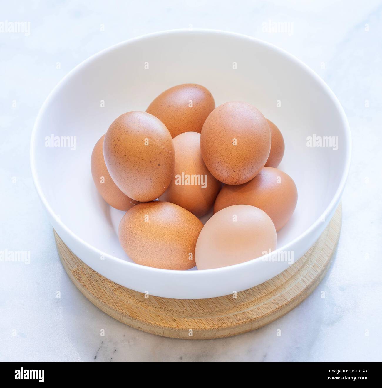 Weiße Schüssel mit braunen Eiern Stockfoto