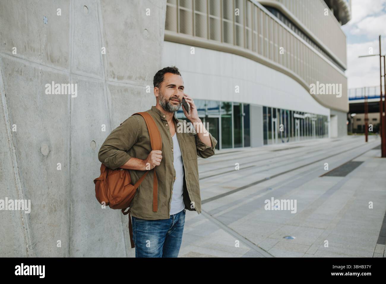 Porträt eines Mannes mittleren Alters, der draußen telefoniert. Stockfoto