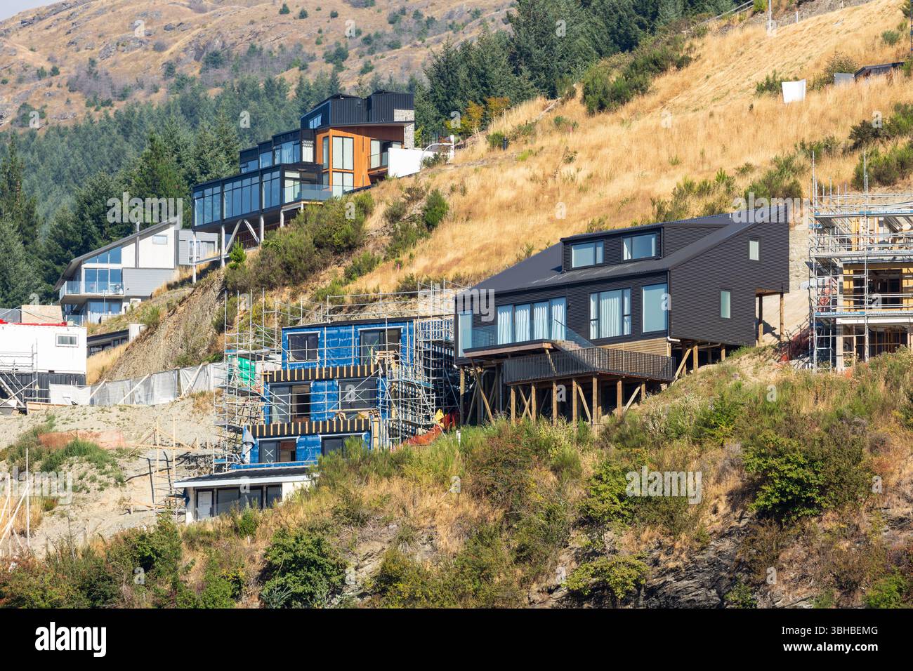 Moderne Häuser am See werden im Bau auf dem Hügel mit Blick auf Lake Wakatipu, Queenstown, Otago, Neuseeland Stockfoto