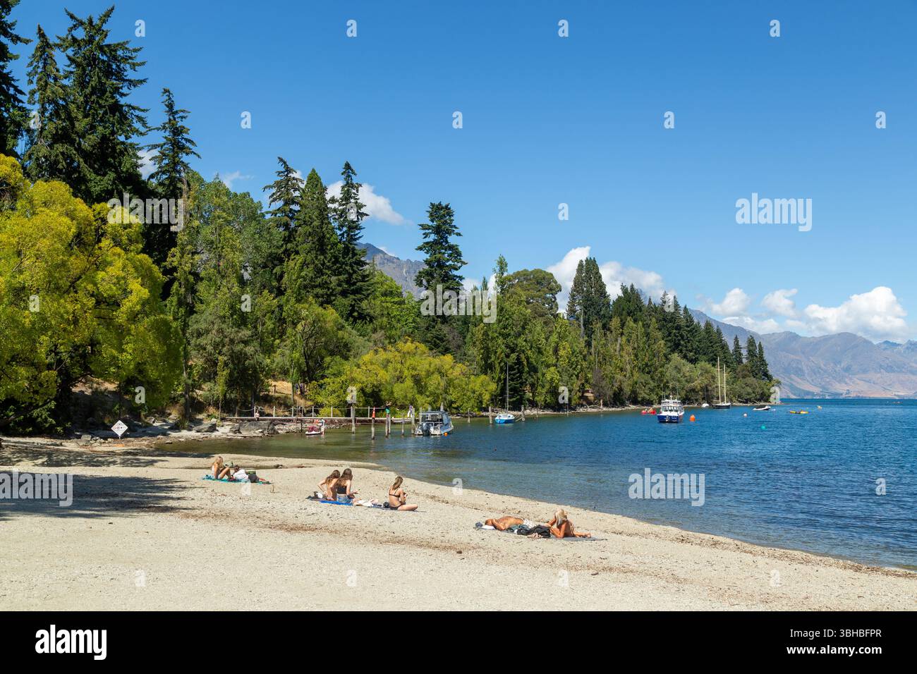 Queenstown Bay Beach mit Queenstown Gardens und Lake Whakatipu an einem Sommertag, Queenstown, Otago, Neuseeland Stockfoto