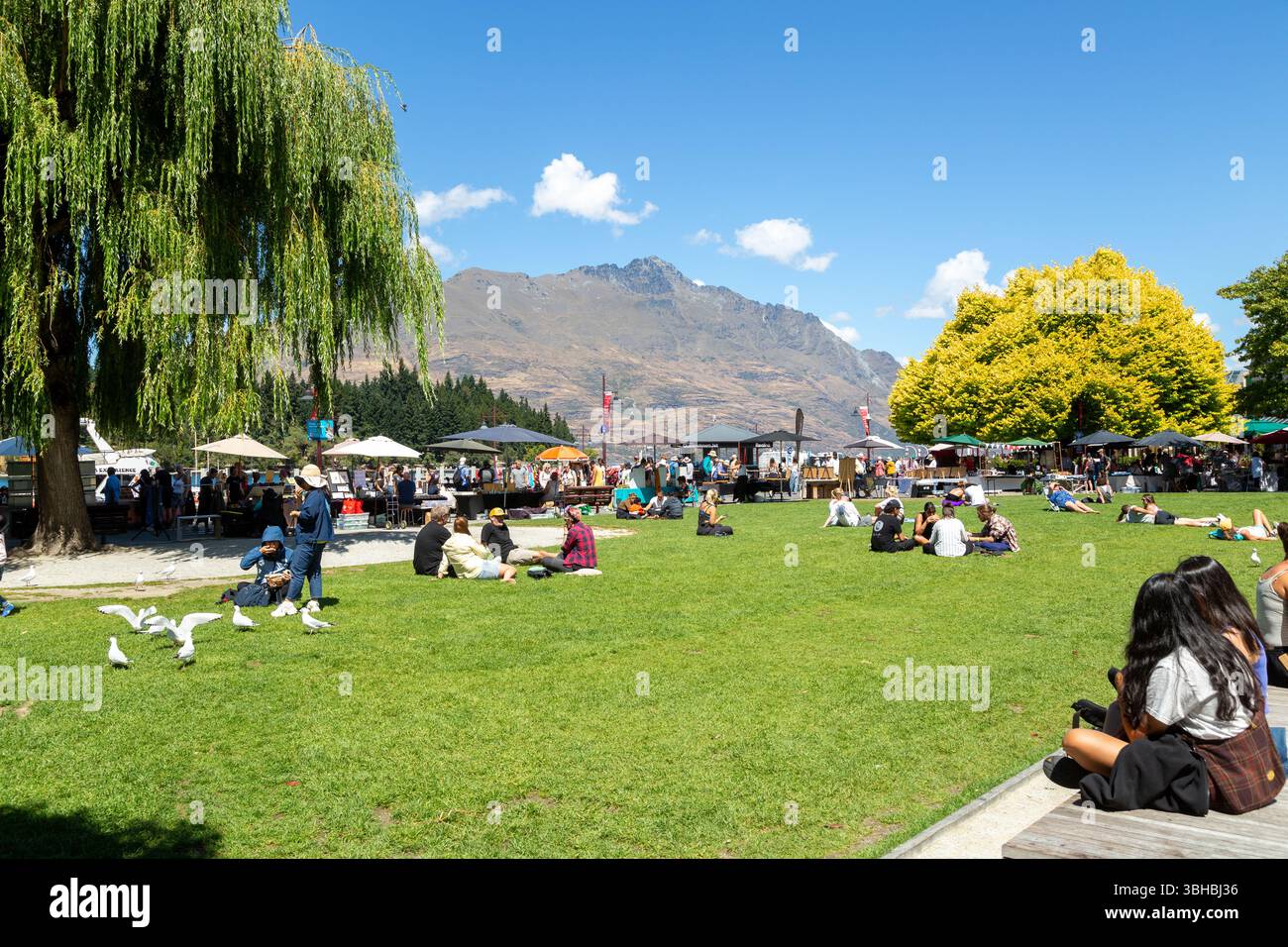 Menschen genießen die Sonne im Earnslaw Park Queenstown, Otago, Neuseeland Stockfoto