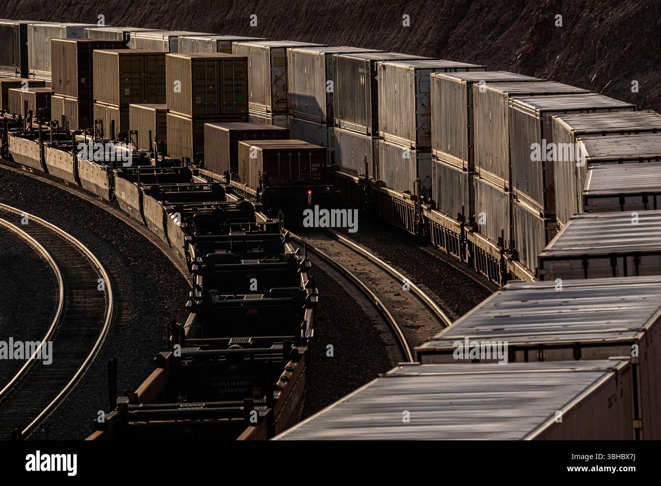 Drei Containerzüge parallel bei Sonnenuntergang Stockfoto