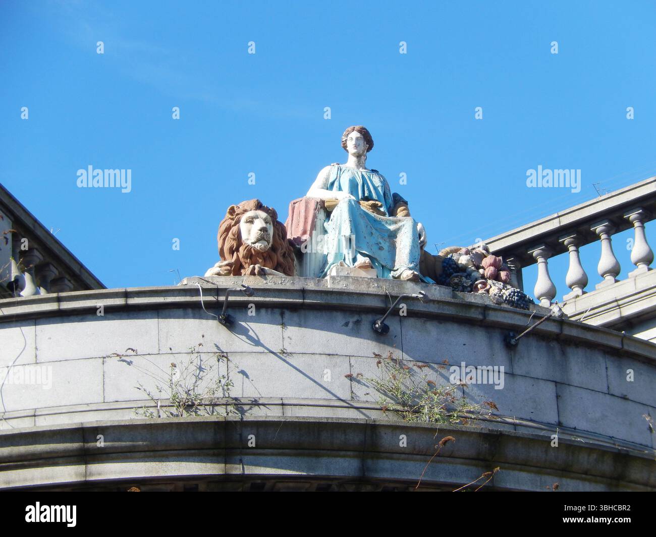 Statue mit Löwe auf dem Gebäudebalkon unter dem klaren blauen Himmel. Aberdeen, Schottland Stockfoto