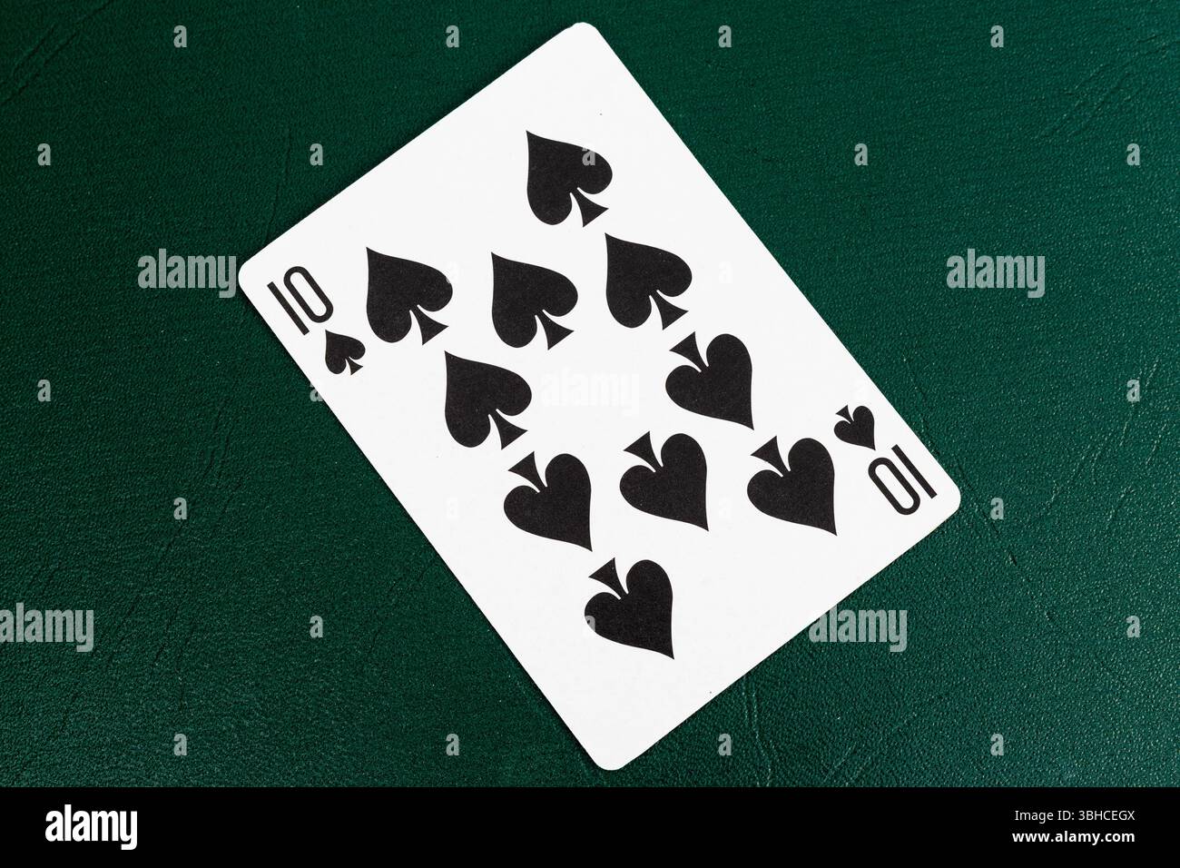 Zehn Pik spielen Karte auf grünem Tisch. Closeup Poker-Thema. Stockfoto