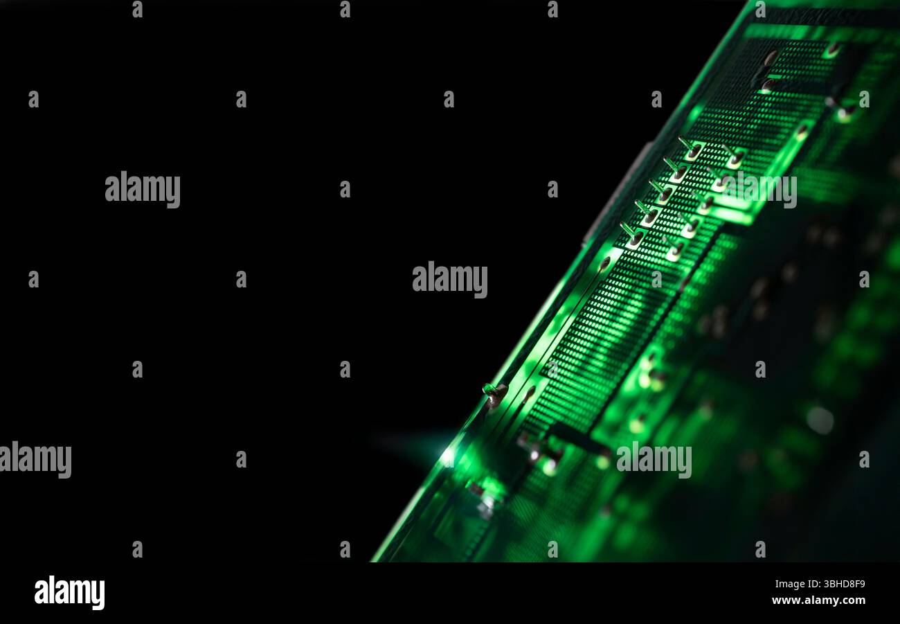Nahaufnahme einer beleuchteten grünen elektronischen Leiterplatte mit elektrischen Komponenten und Anschlüssen, isoliert auf schwarzem, selektivem Fokus. Kopierbereich Stockfoto