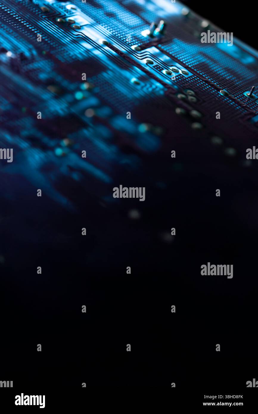 Nahaufnahme einer blau beleuchteten elektronischen Leiterplatte mit elektrischen Komponenten und Anschlüssen, isoliert auf schwarzem, selektivem Fokus. Kopierbereich Stockfoto