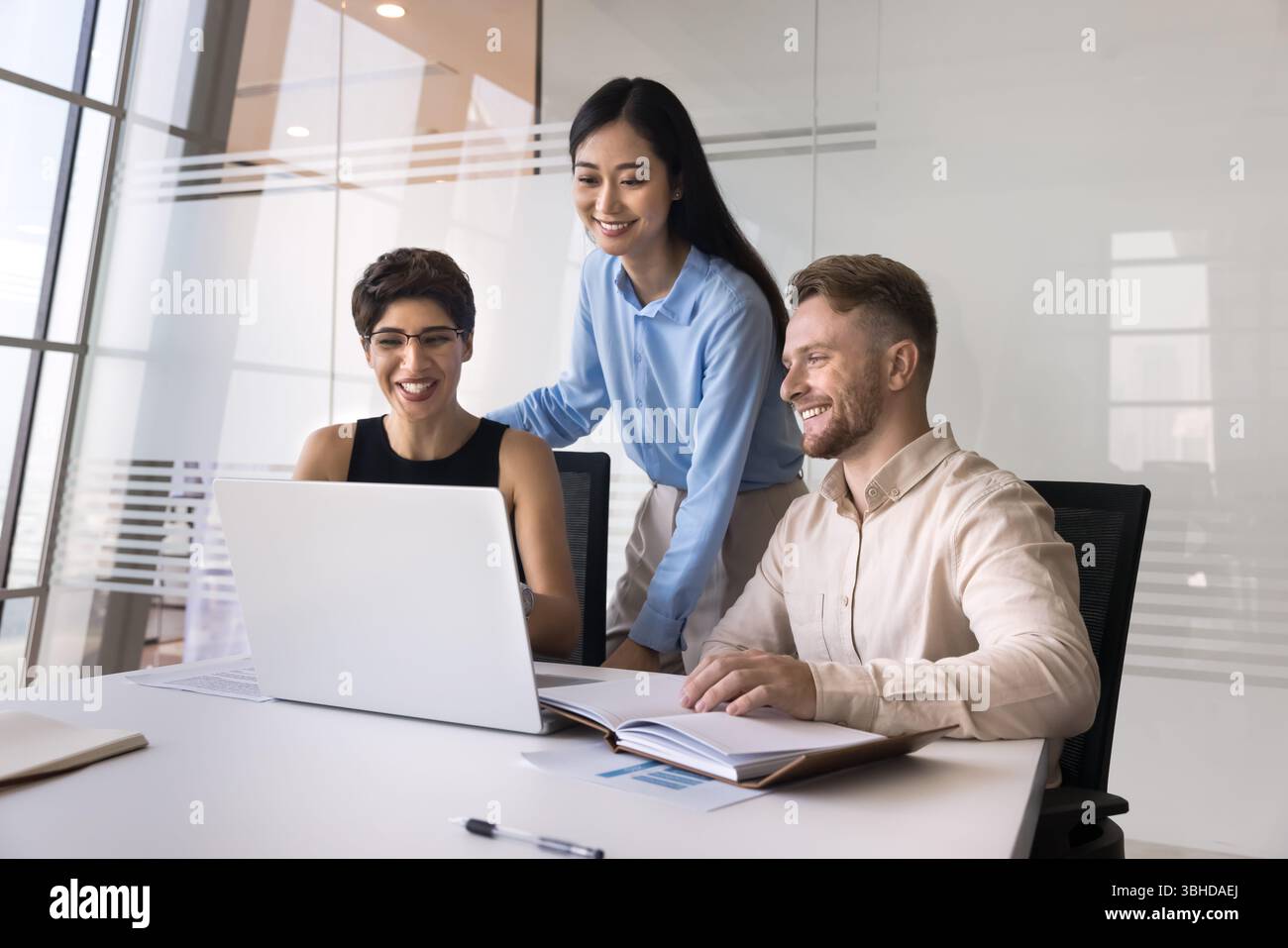 Mitarbeiter lernen neue KI-Tools oder -Software für Unternehmen mithilfe eines Laptops Stockfoto