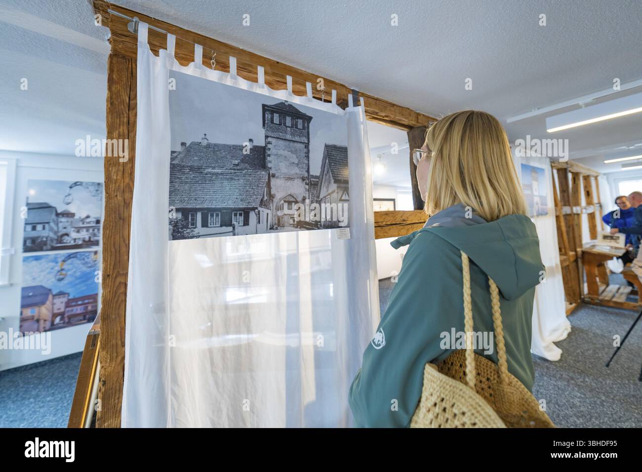 Frau mit Blick auf historische Fotografie in einem modern gestalteten Raum, Familienfeier in Neubulach, Bezirk Calw, Deutschland, Europa Stockfoto