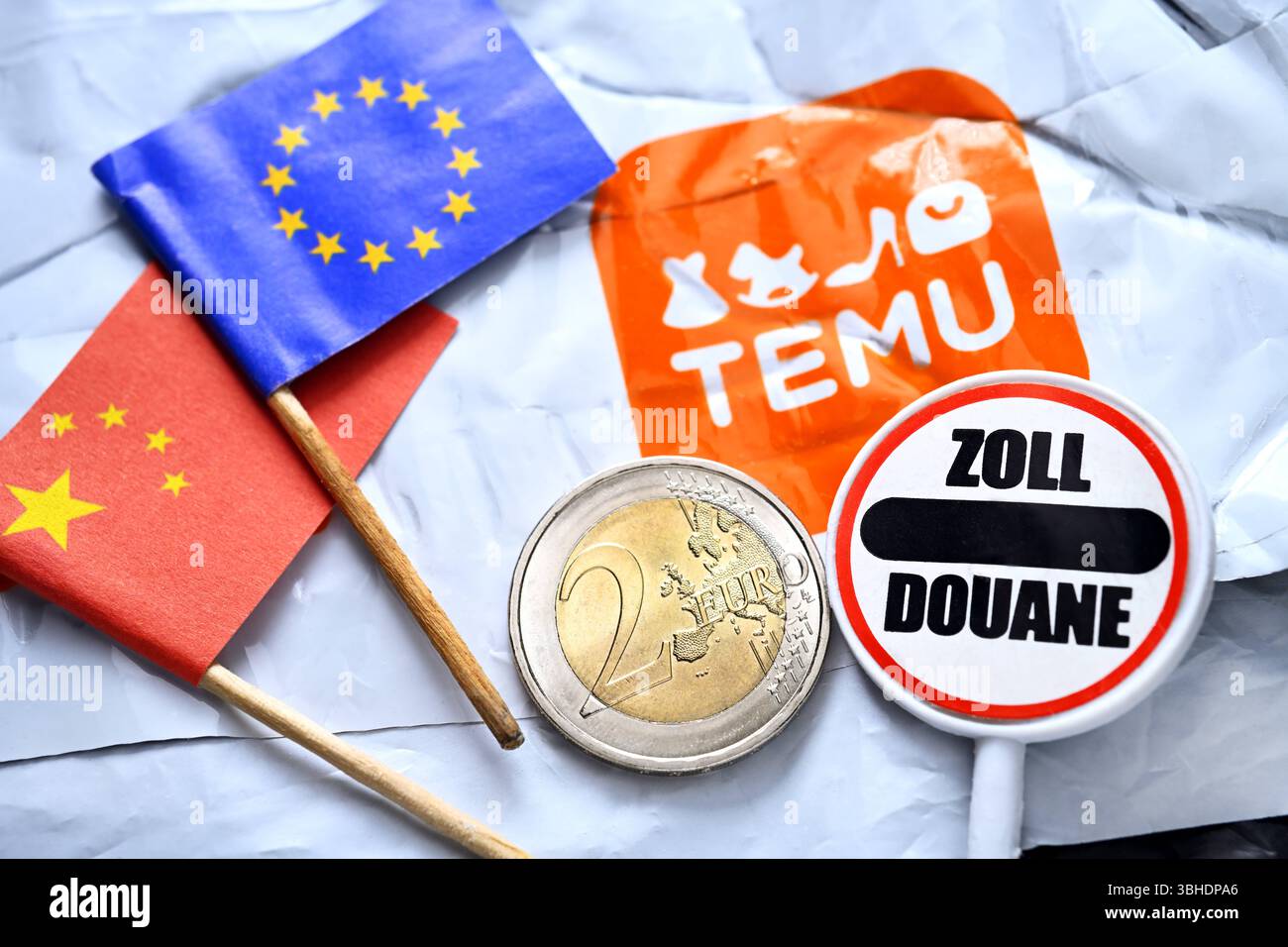 Temu-Sendung mit Zollschild und zwei-Euro-Münze, Zollerhebung für Lieferungen von Billighändlern nach Europa *** Temu-Sendung mit Zollschild und zwei Euro-Münze, Zollerhebung für Lieferungen von Billighändlern nach Europa Stockfoto