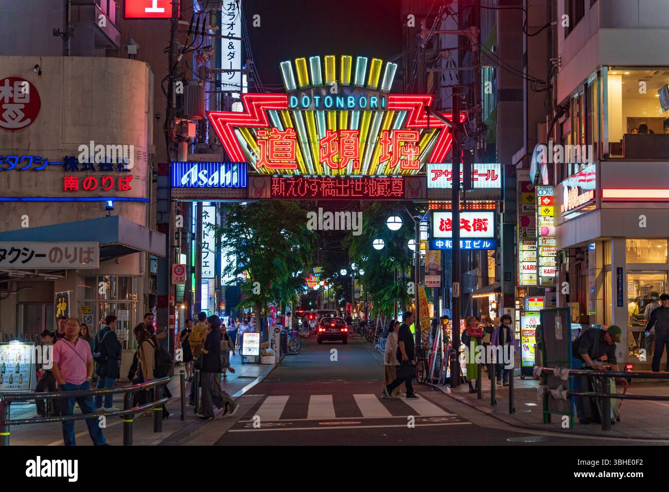 Nächtlicher Blick auf die Dotonbori Einkaufsstraße mit Menschenmassen in Osaka, Japan Stockfoto