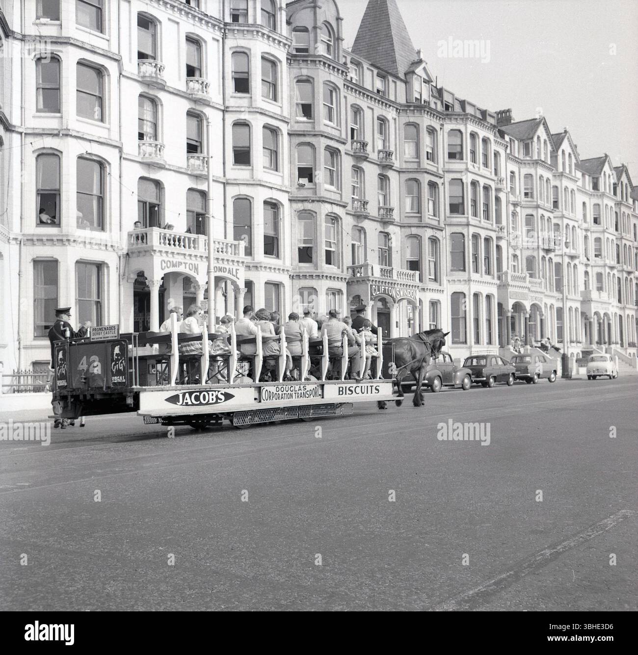 1950er Jahre, historisch, Douglas, Isle of man, Großbritannien, eine Pferdestraßenbahn, die von der Douglas Corporation Transport betrieben wird. Nr. 42, zu den Promenaden Derby Castle und Electric Railway Station, Jakob's Biscuits wurden auf der Seite der Straßenbahn gefördert. Große viktorianische Gästehäuser säumen die Straße. Stockfoto