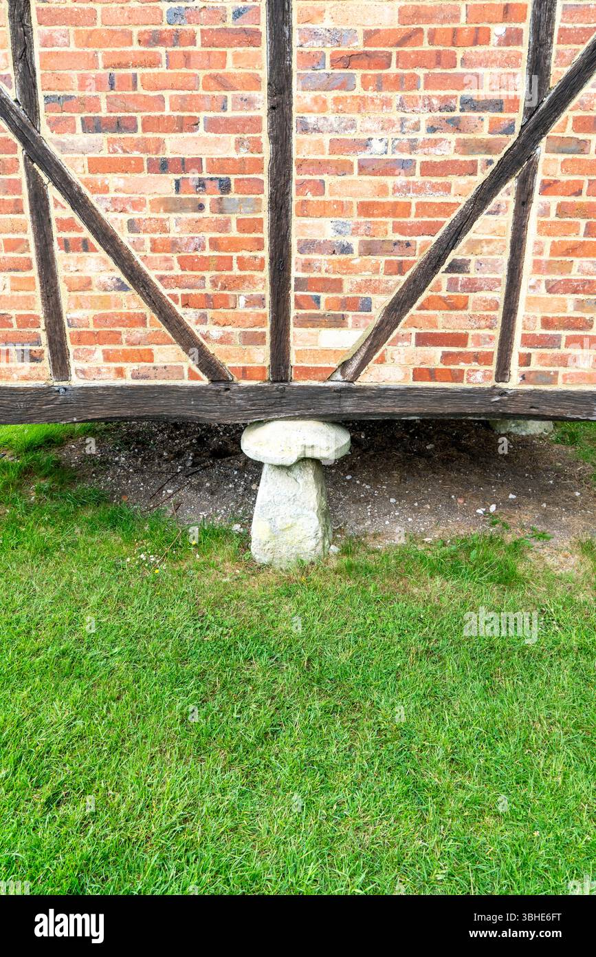 Staddle Stone für ein Gebäude aus rotem Backstein und Holz Stockfoto
