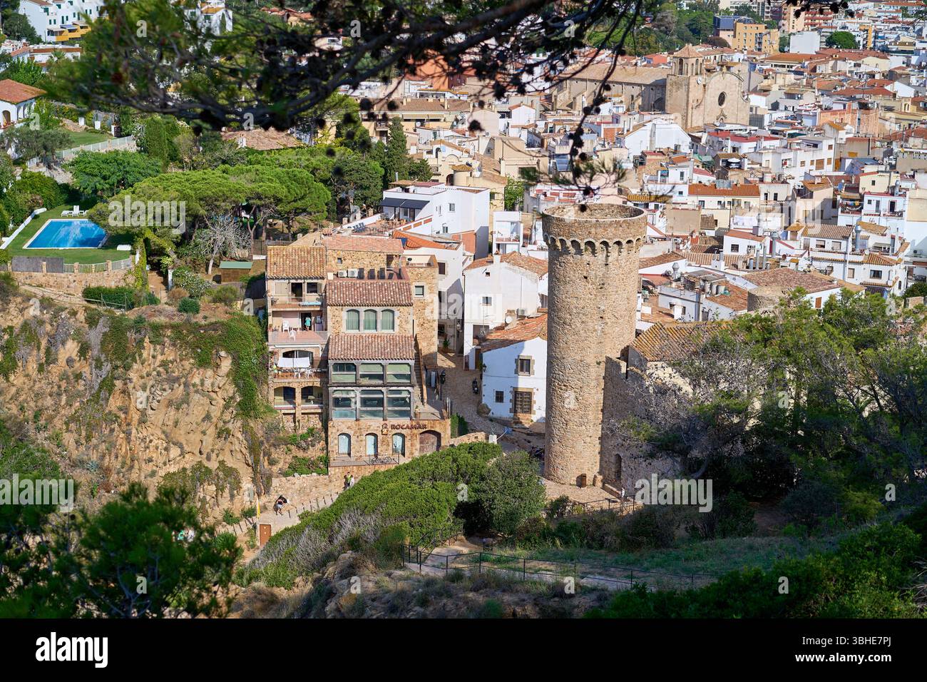 Malerischer Blick auf die Stadt Tossa de Mar, mit einem Steinturm und traditionellen Gebäuden mit Terrakottadächern. Stockfoto