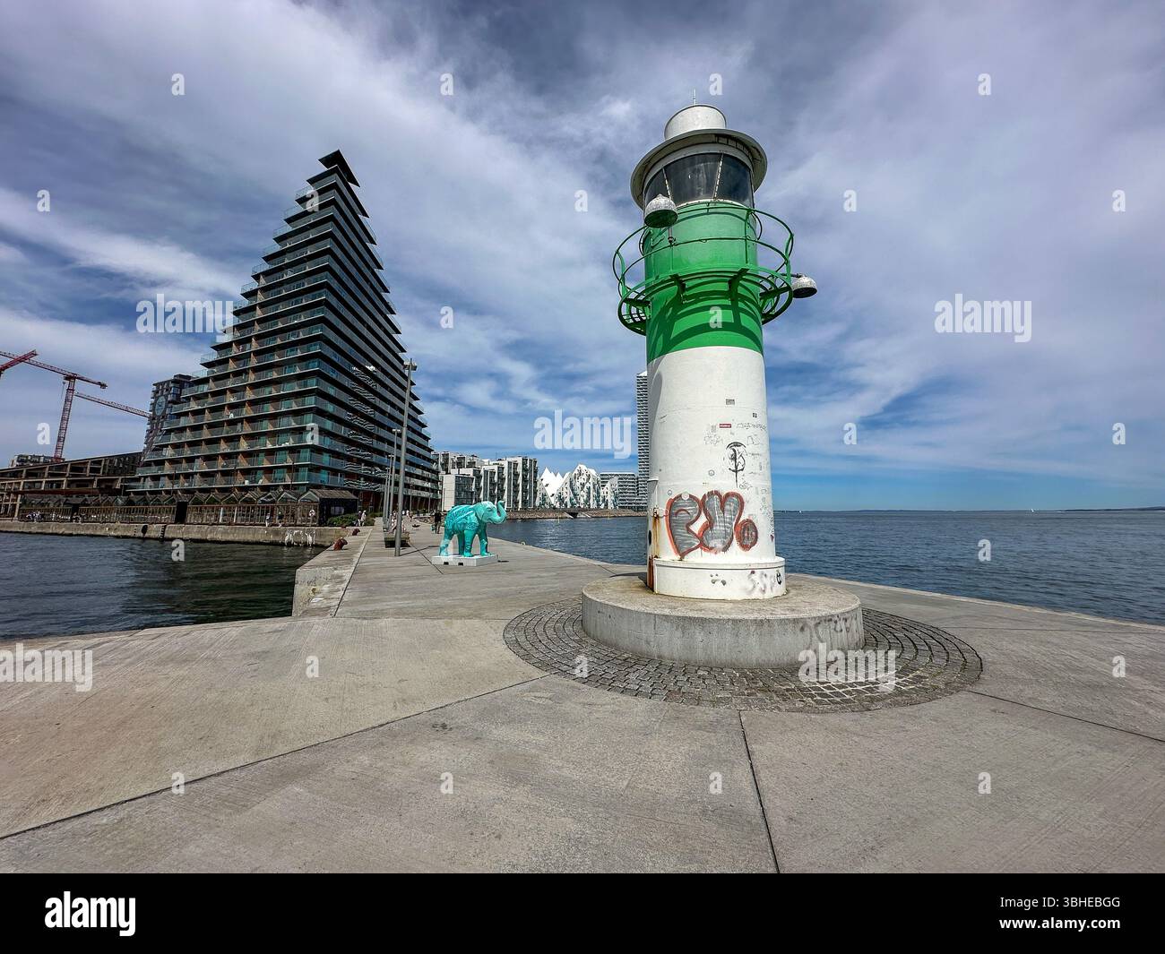 Aarhus, Dänemark: Leuchtturm „Bugten Fyr“ vor Skyline von Aarhus Ø mit Wohnkomplex „Isbjerget“ und Hochhaus „Light*House“ am Wasser Stockfoto