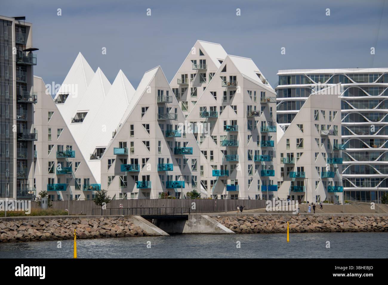 Aarhus, Dänemark: Leuchtturm „Bugten Fyr“ vor Skyline von Aarhus Ø mit Wohnkomplex „Isbjerget“ und Hochhaus „Light*House“ am Wasser Stockfoto