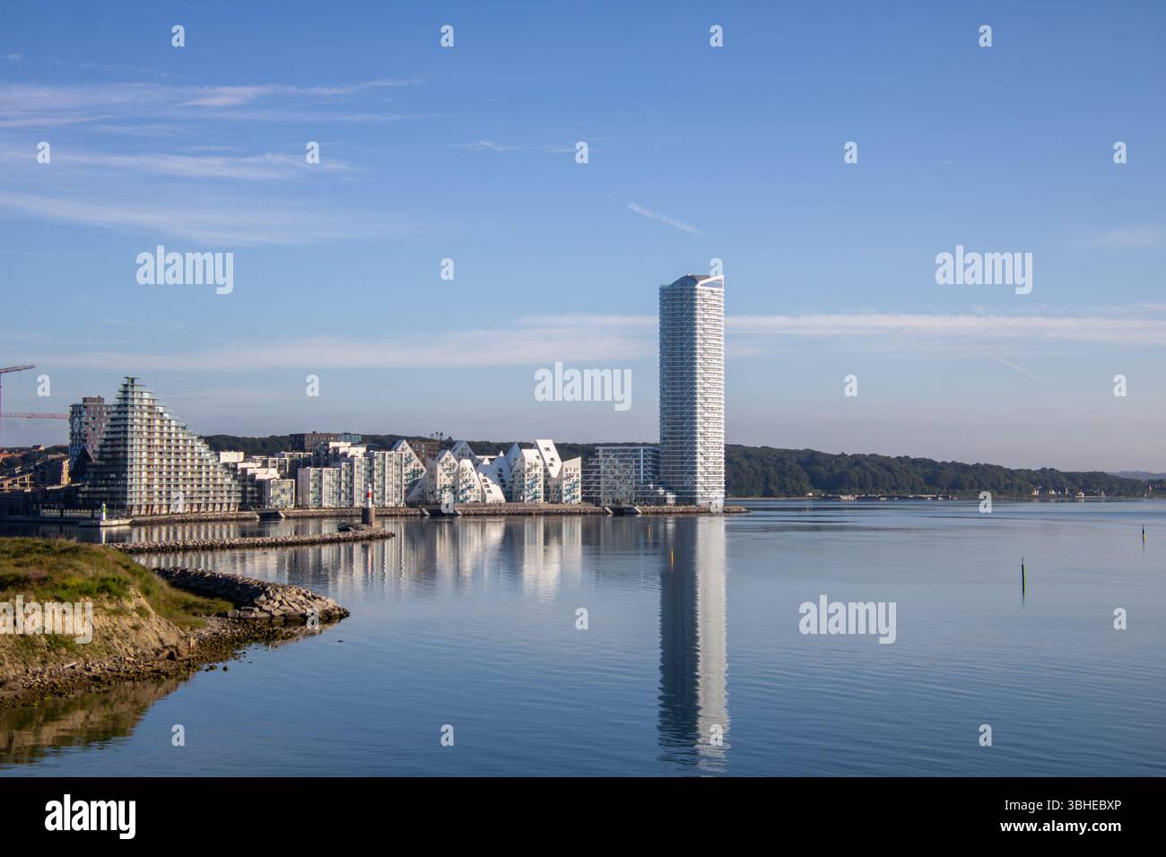 Aarhus, Dänemark: Leuchtturm „Bugten Fyr“ vor Skyline von Aarhus Ø mit Wohnkomplex „Isbjerget“ und Hochhaus „Light*House“ am Wasser Stockfoto