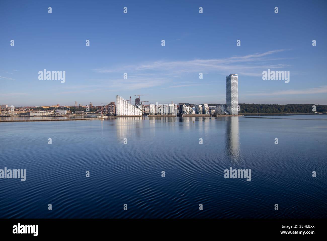 Aarhus, Dänemark: Leuchtturm „Bugten Fyr“ vor Skyline von Aarhus Ø mit Wohnkomplex „Isbjerget“ und Hochhaus „Light*House“ am Wasser Stockfoto