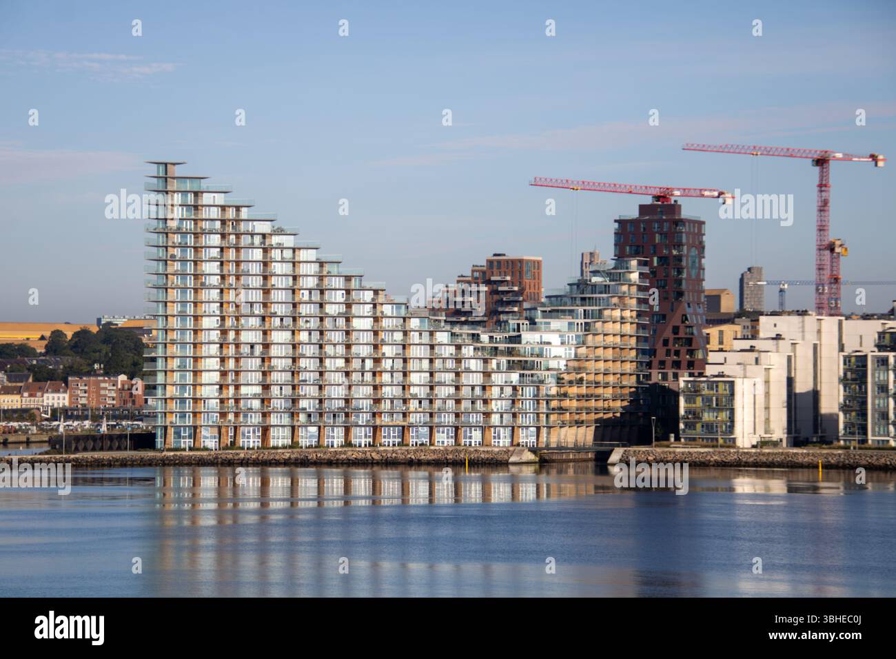 Aarhus, Dänemark: Leuchtturm „Bugten Fyr“ vor Skyline von Aarhus Ø mit Wohnkomplex „Isbjerget“ und Hochhaus „Light*House“ am Wasser Stockfoto