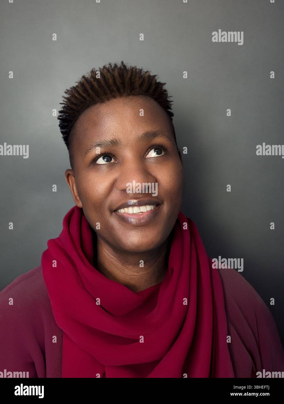 Fröhliches Porträt einer schwarzen Frau mit rotem Schal und Dreadlocks Stockfoto