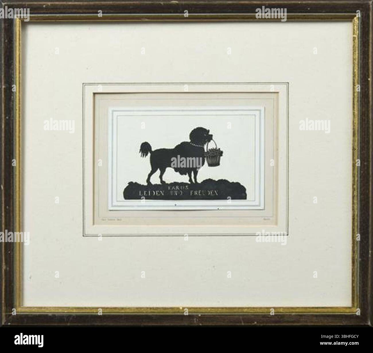Karl Fröhlich - die Silhouette eines Hundes, die einen Korb mit Blumen im Mund hält und eine ausgeschnittene Inschrift hat. Stockfoto