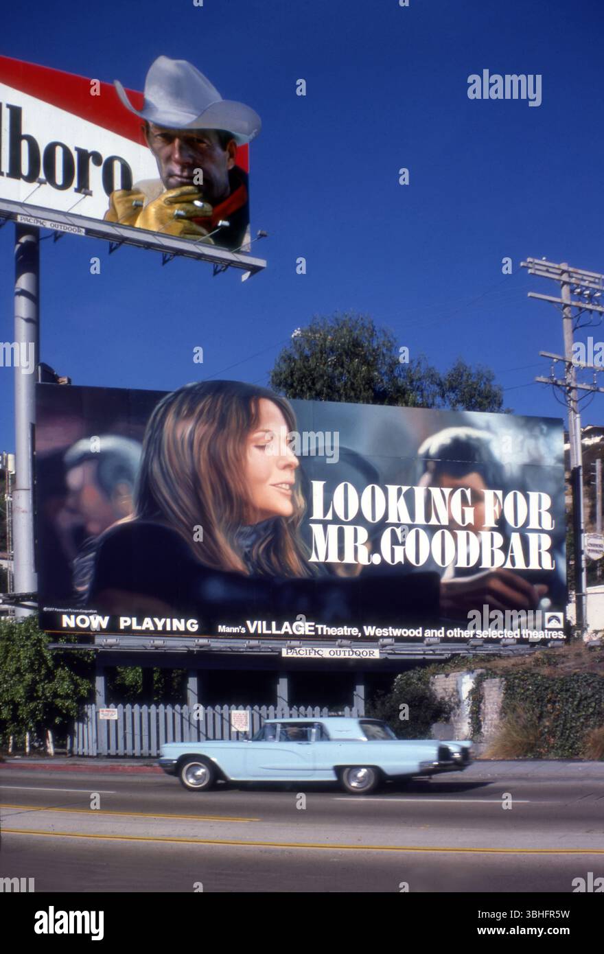Reklametafeln auf dem Sunset Strip mit Diane Keaton im Film auf der Suche nach Mr. Goodbar und dem Marlboro-Mann, mit einem klassischen Thunderbird-Auto, das 1977 vorbeifuhr, Los Angeles, Kalifornien, USA Stockfoto