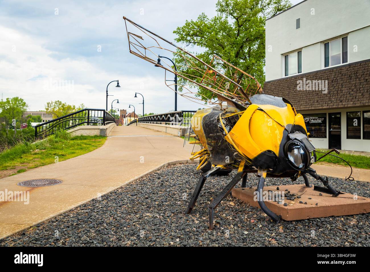 Eau Claire, WI, USA - 14. Mai 2025: Öffentliche Kunstskulptur einer Riesenbiene in der Nähe einer Brücke in Eau Claire Wisconsin Stockfoto