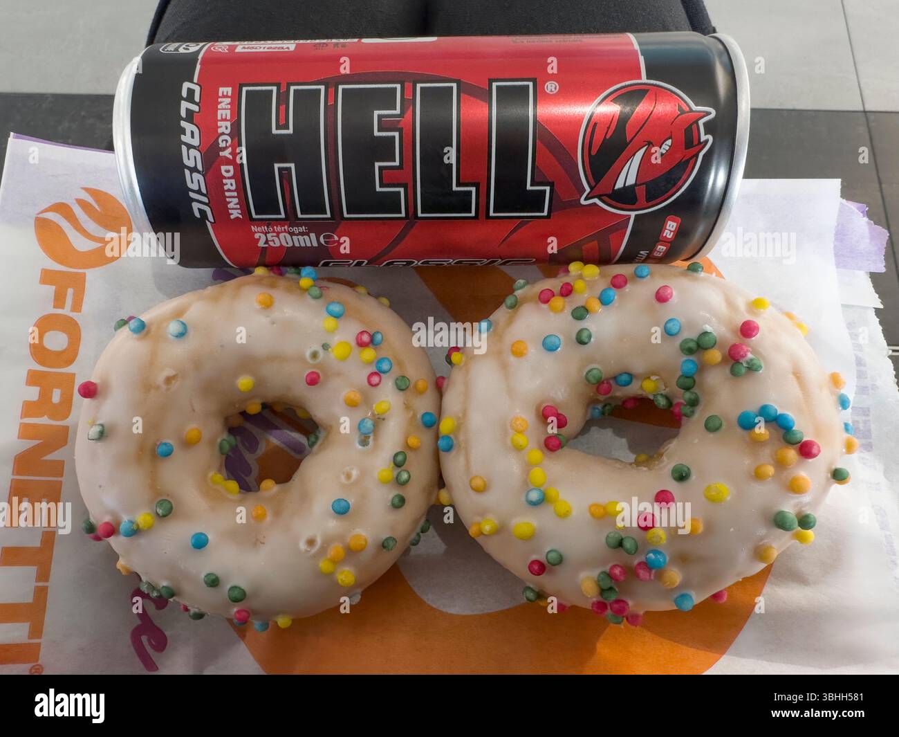 Ungesunder zuckerhaltiger Snack aus Energy Drink und geeisten Donuts ungarn Stockfoto