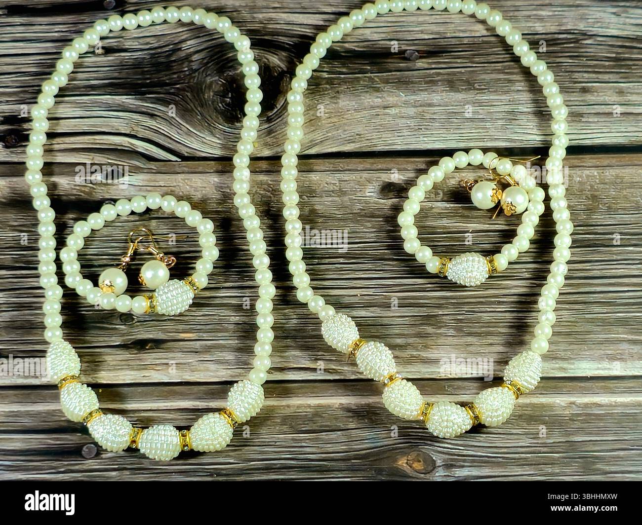 Stretcharmbänder mit Perlen, Perlenohrringe und Halskette mit weißen Perlen, Damendekoration und Accessoires Stockfoto